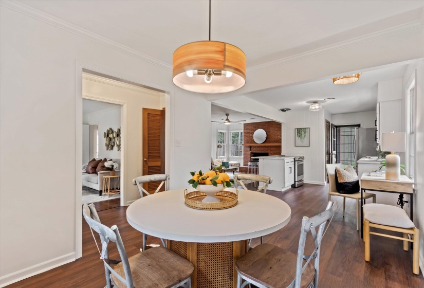 Dining area with a wood-finish flooring, a contemporary drum pendant light fixture, and an open layout to additional living spaces