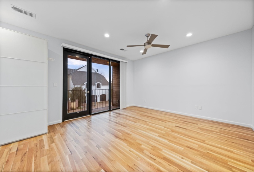 Spacious room featuring wood-finish flooring, recessed lighting, and a contemporary ceiling fan