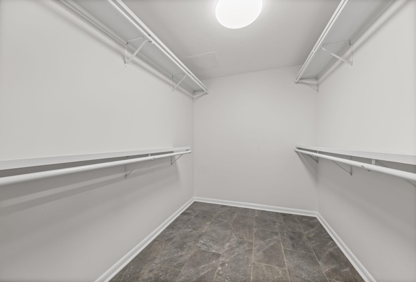 Walk-in closet featuring grey tile flooring, white walls, and a ceiling-mounted light fixture