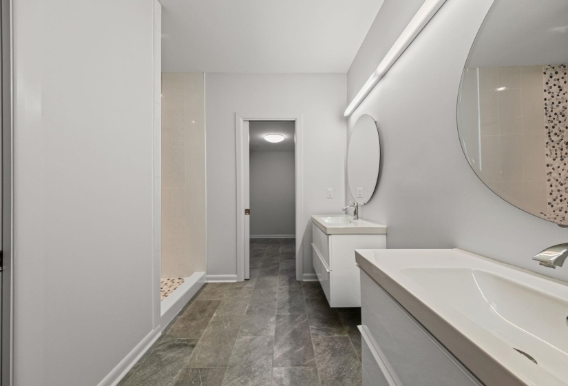 Modern bathroom featuring a dual vanity with undermount sinks and wall-mounted mirrors