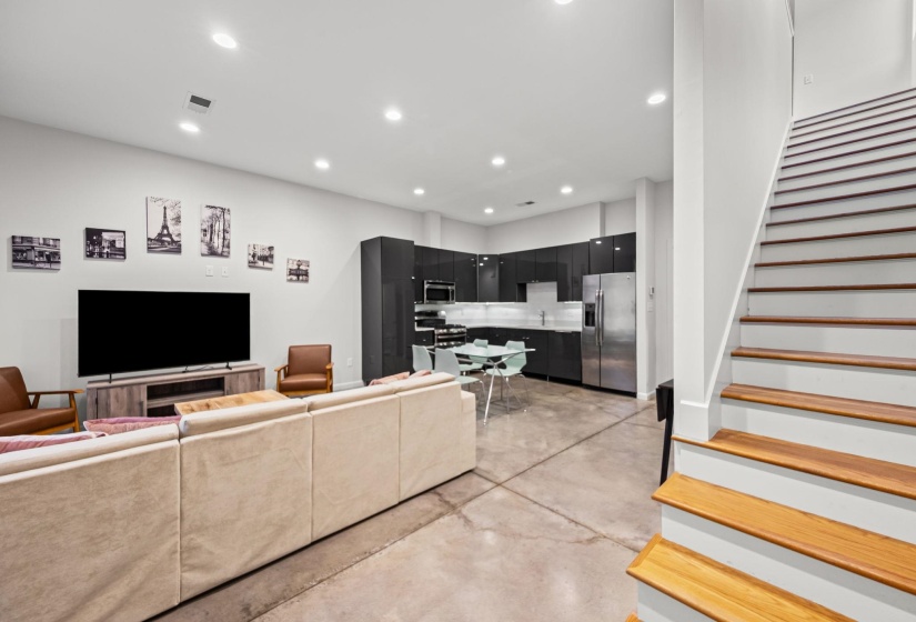 Open-concept living area with concrete flooring and recessed lighting