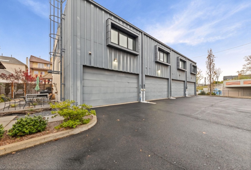 Modern industrial-style building featuring corrugated metal siding and multiple garage bays