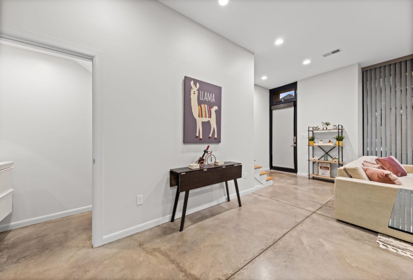 Expansive open-concept living area featuring concrete flooring and recessed lighting