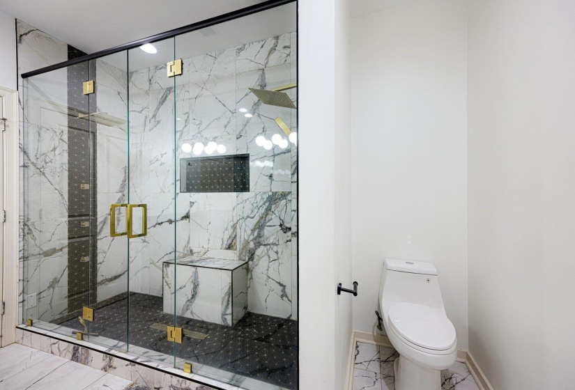 Bathroom with a marble finish shower and marble look tiles