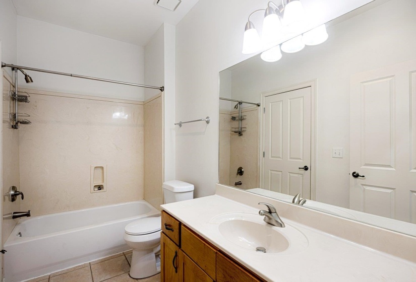 Bathroom with bathing tub / shower combination, vanity, and light tile patterned flooring