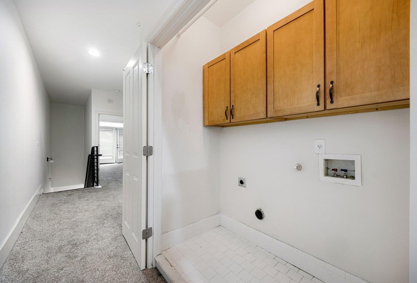 Laundry area with cabinet space, hookup for a gas dryer, light colored carpet, washer hookup, and hookup for an electric dryer