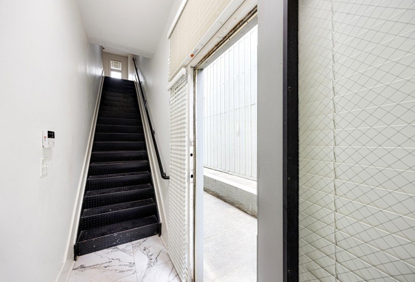 Staircase featuring baseboards and marble look tiles