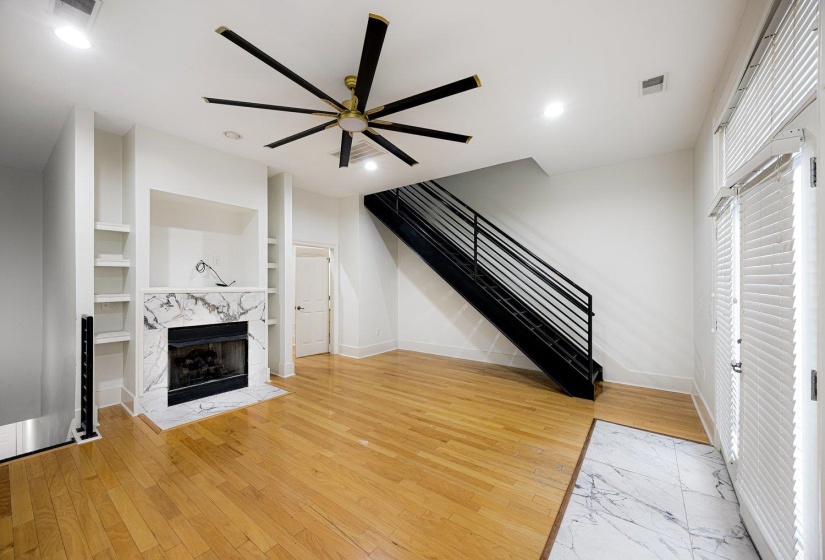 Unfurnished living room with a ceiling fan, light wood-style floors, a high end fireplace, recessed lighting, and built in features