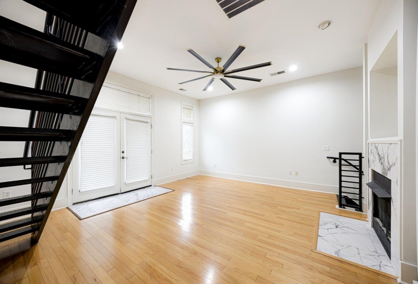 Unfurnished living room featuring a high end fireplace, light wood finished floors, a ceiling fan, and recessed lighting