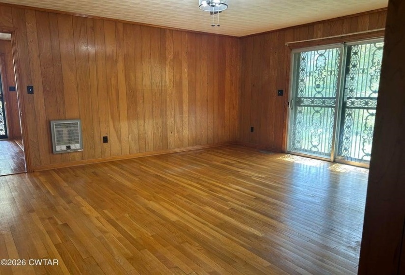 Room featuring wood plank wall paneling and hardwood flooring
