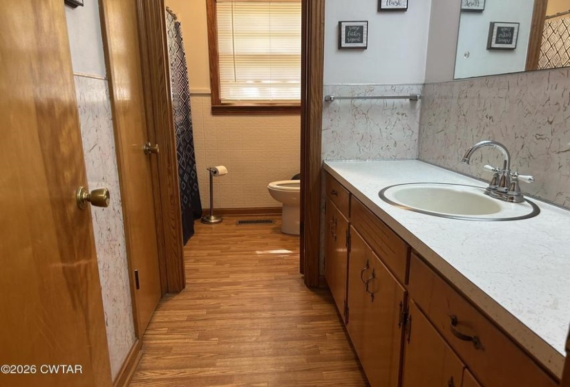 Bathroom vanity with an integrated oval sink, chrome faucet, and a light-colored countertop