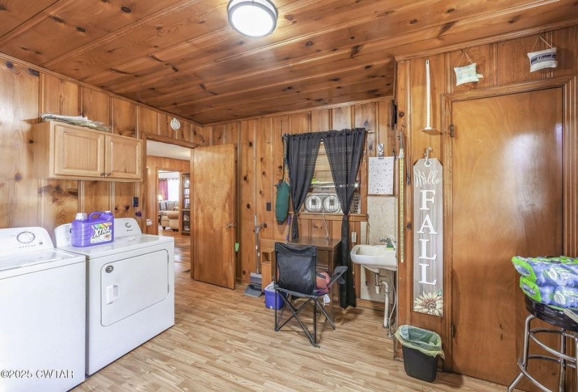 Utility area featuring wood-paneled walls and ceiling, wood-finish flooring, and a ceiling-mounted light fixture