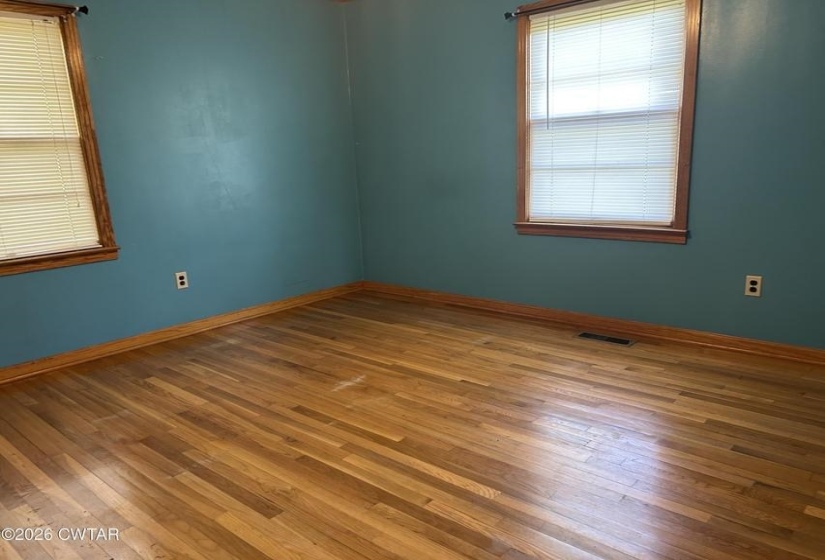 Hardwood flooring with natural wood baseboards and window trim
