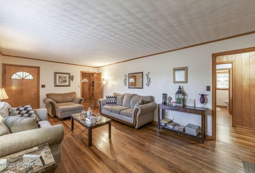 Living area featuring wood-finish flooring, white walls, and wood trim