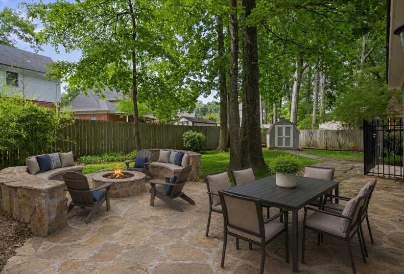 Outdoor patio with stone firepit and built-in stone benches perfect for relaxing or entertaining.                                             Virtually Staged Photo