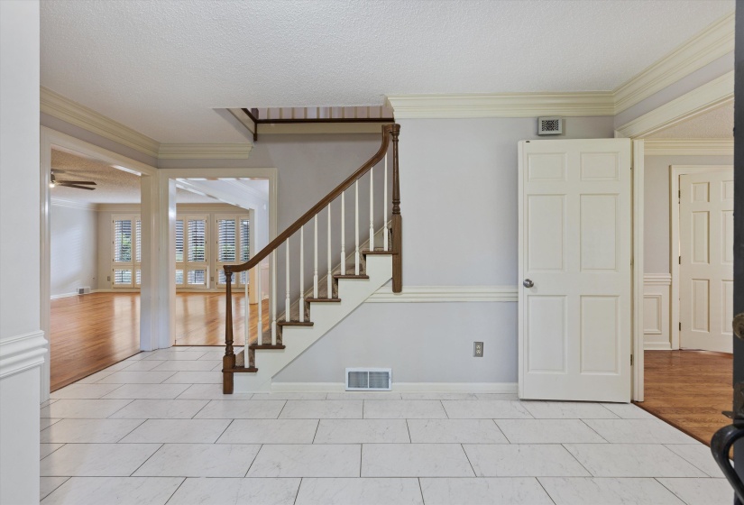 Welcoming Entrance Foyer with tile flooring, chair      molding, and crown molding offering an elegant                           first impression.