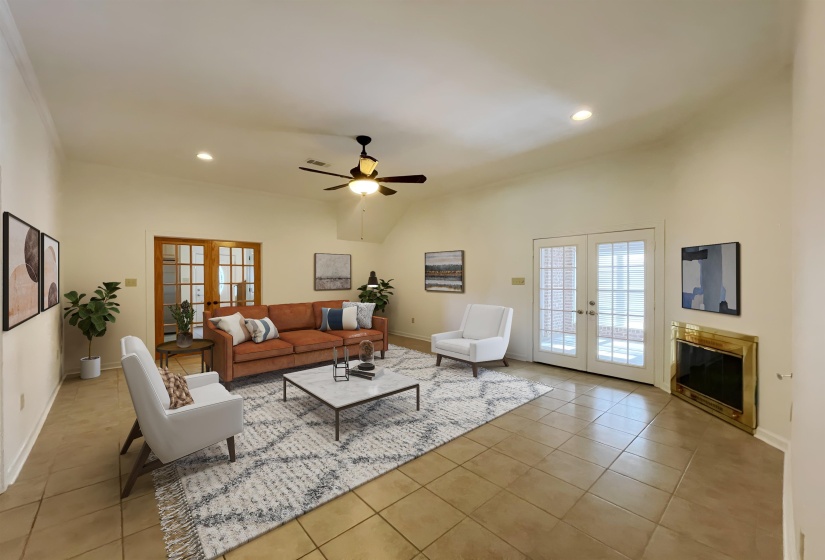 Vaulted ceilings with recessed lighting and ceiling fan, two sets of double French doors, and tile flooring