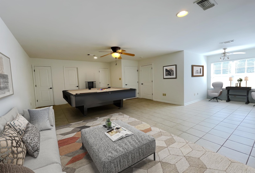 Spacious room featuring light-colored tile flooring and multiple white panel doors