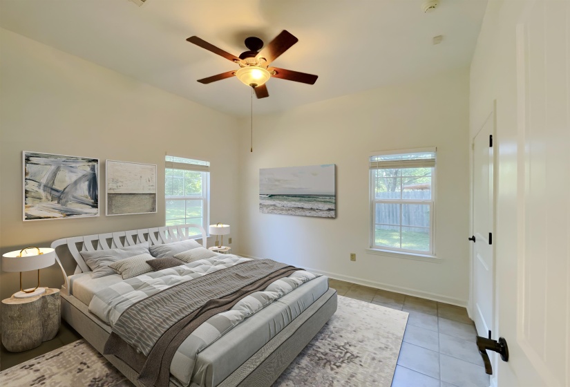 Vaulted ceiling bedroom featuring a ceiling fan with light, two windows, and tile flooring