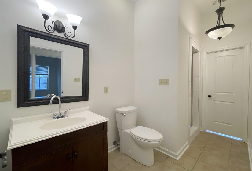 Bathroom featuring a dark wood finish vanity with integrated sink, chrome faucet, and white countertop