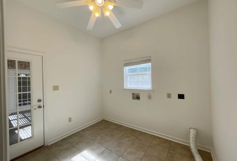 Utility room featuring a ceiling fan with integrated lighting, tiled flooring, and a single window with blinds