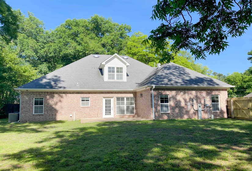 Rear exterior with a brick facade and a gray shingle roof