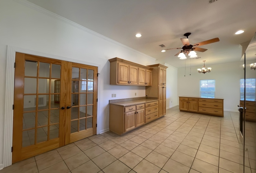 Light wood-finish French doors open to an interior space