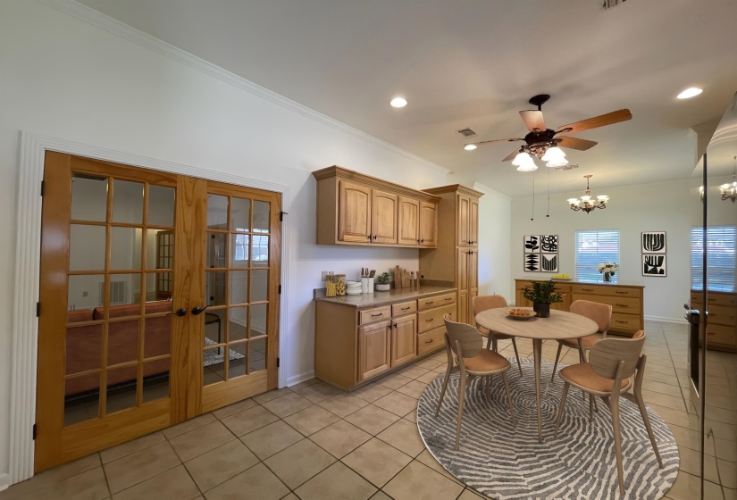 Open-concept area featuring light tile flooring and crown molding