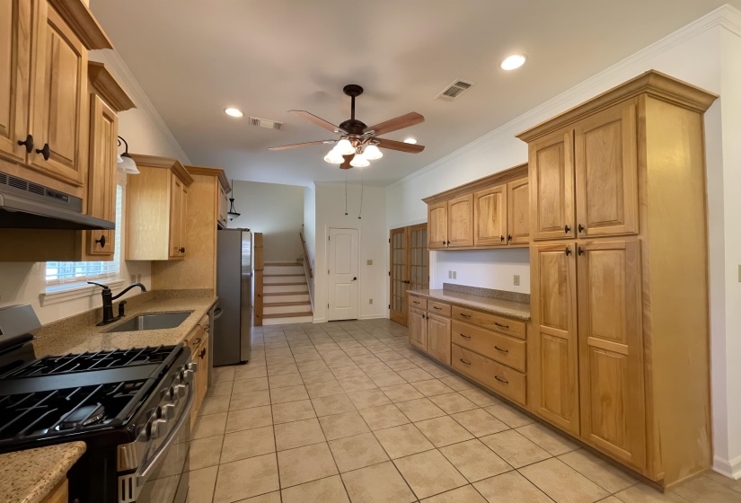 Spacious kitchen featuring extensive wood cabinetry, granite-style countertops, stainless steel appliances, and tile flooring