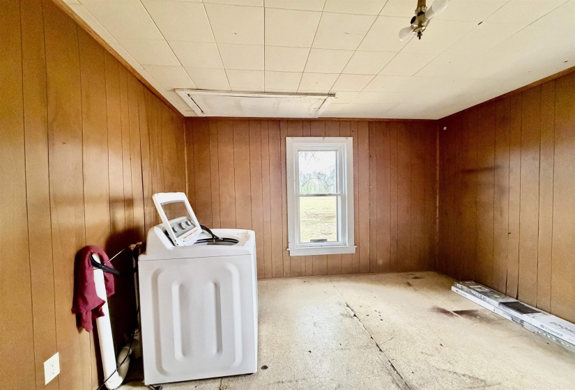 Laundry area featuring washing machine and clothes dryer and wooden walls