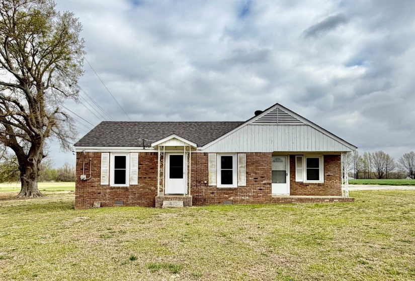 View of front of property featuring brick siding, a front yard, crawl space, and roof with shingles