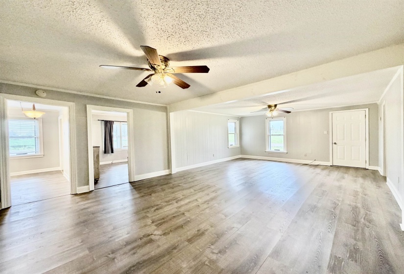 Spare room featuring a textured ceiling, ceiling fan, and light wood-style flooring