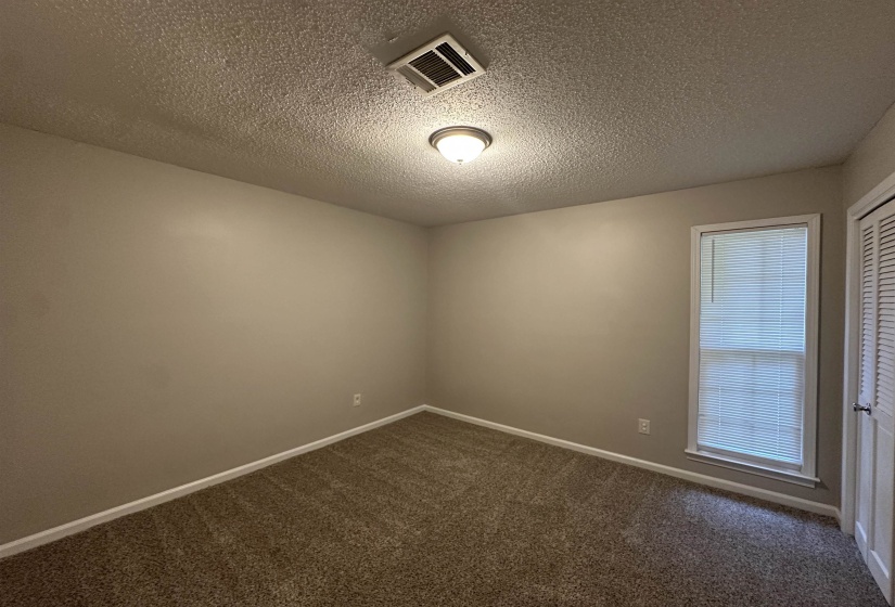 Interior room featuring neutral wall paint, textured ceiling, and carpet flooring