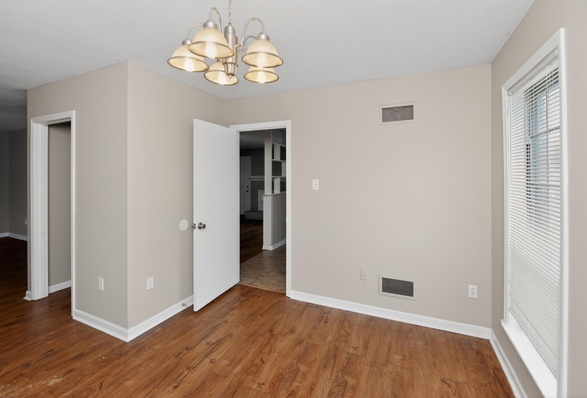 Interior room with wood-finish flooring, neutral wall paint, and white trim