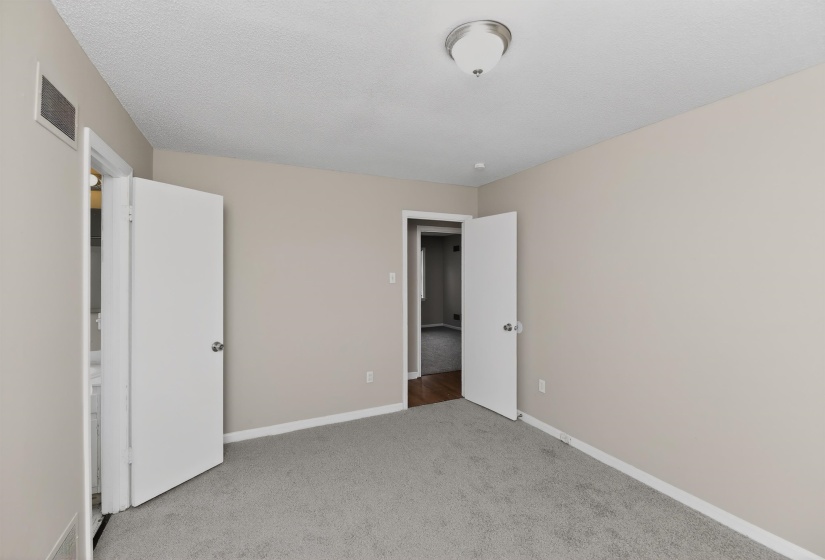 Carpeted room featuring a ceiling-mounted light fixture, light gray wall paint, and white trim