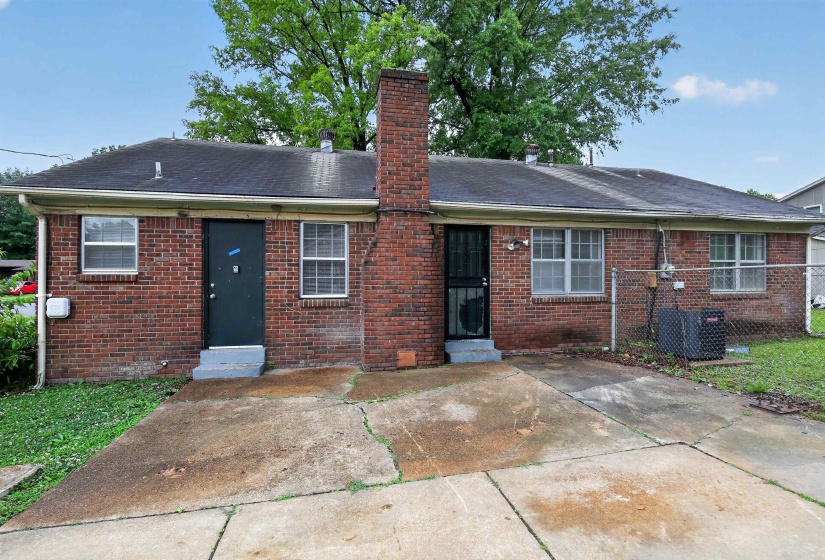 Brick exterior featuring a dark asphalt shingle roof