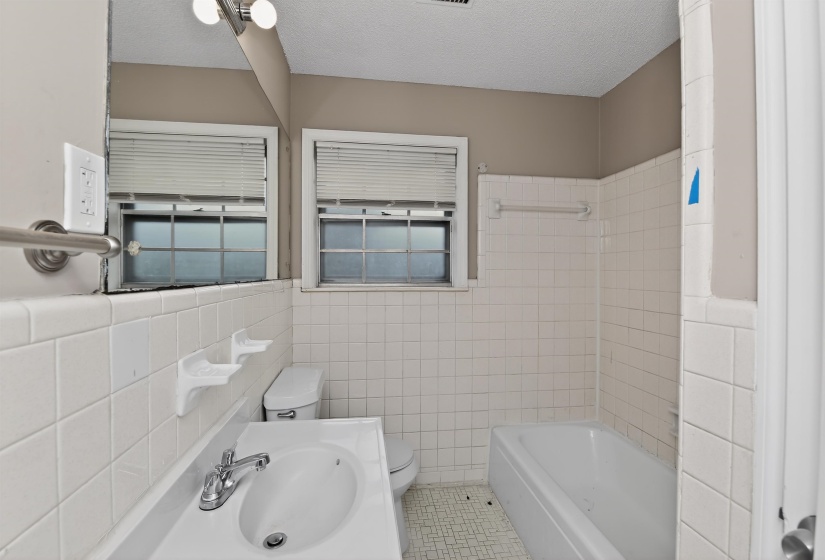 Bathroom featuring a single vanity, integrated sink, and an overhead vanity light