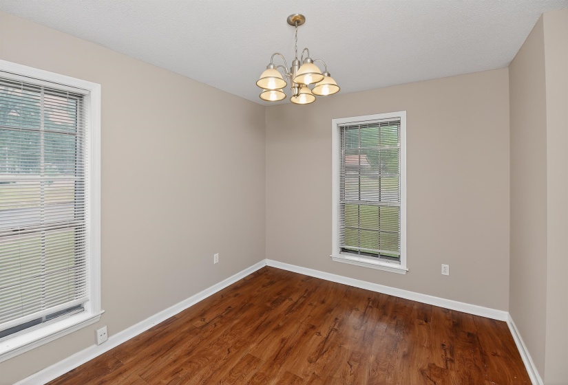 Room featuring wood-finish flooring, neutral wall paint, and white trim