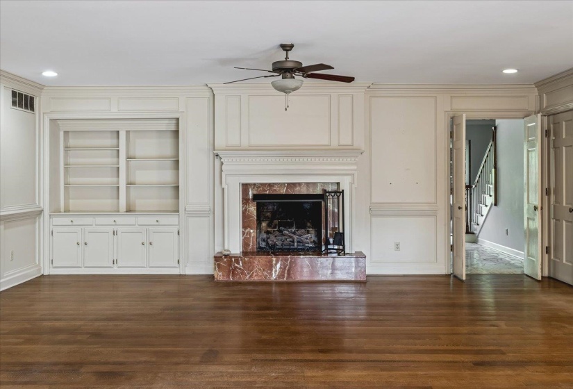 Spacious room featuring wood-finish flooring and extensive crown molding