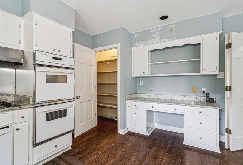 Kitchen featuring white cabinetry, granite countertops, and wood-finish flooring