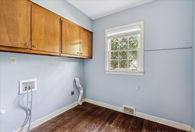 Laundry area with wood-finish flooring and light blue walls