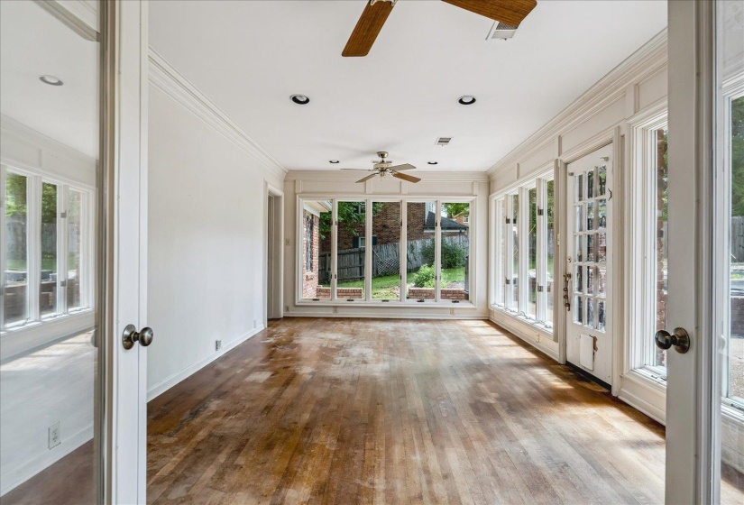 Expansive sunroom featuring wood-finish flooring, recessed lighting, and dual ceiling fans