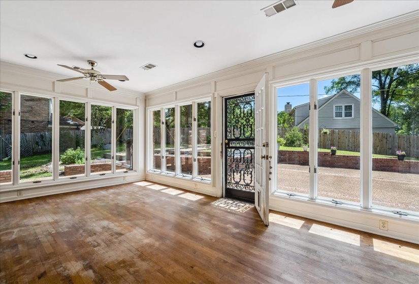 Room featuring extensive window walls, wood-finish flooring, a ceiling fan, recessed lighting, and an ornate security screen door