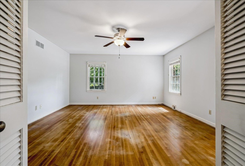 Spacious room featuring wood-finish flooring and white walls