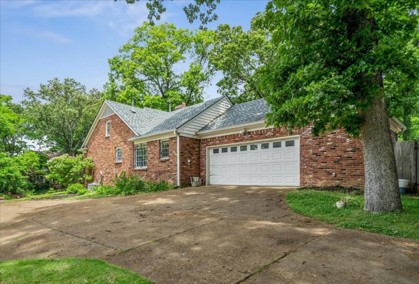 Brick exterior with a gabled roofline, featuring a two-car garage with a white panel door