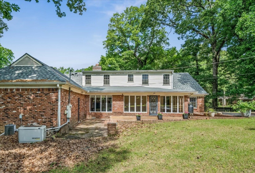 Expansive brick and siding exterior featuring a full-length patio