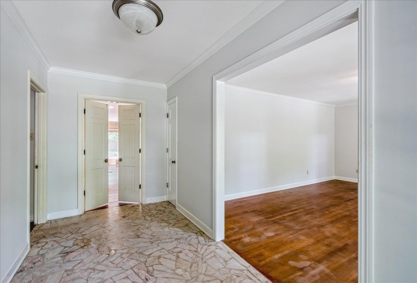 Foyer featuring a natural stone-look tile floor, crown molding, and a flush mount ceiling fixture