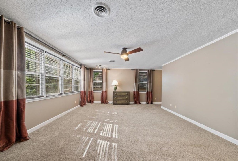 Primary Bedroom with a textured ceiling, carpet, ceiling fan, and crown molding