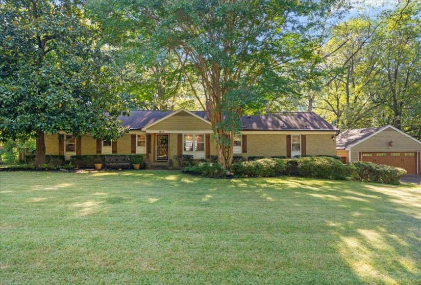 Ranch-style house with brick siding, covered porch, a front lawn, and a garage.