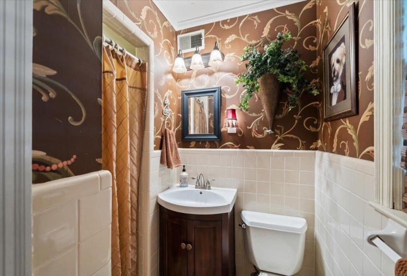 Full bathroom featuring wallpapered walls, vanity, tile walls, and a shower